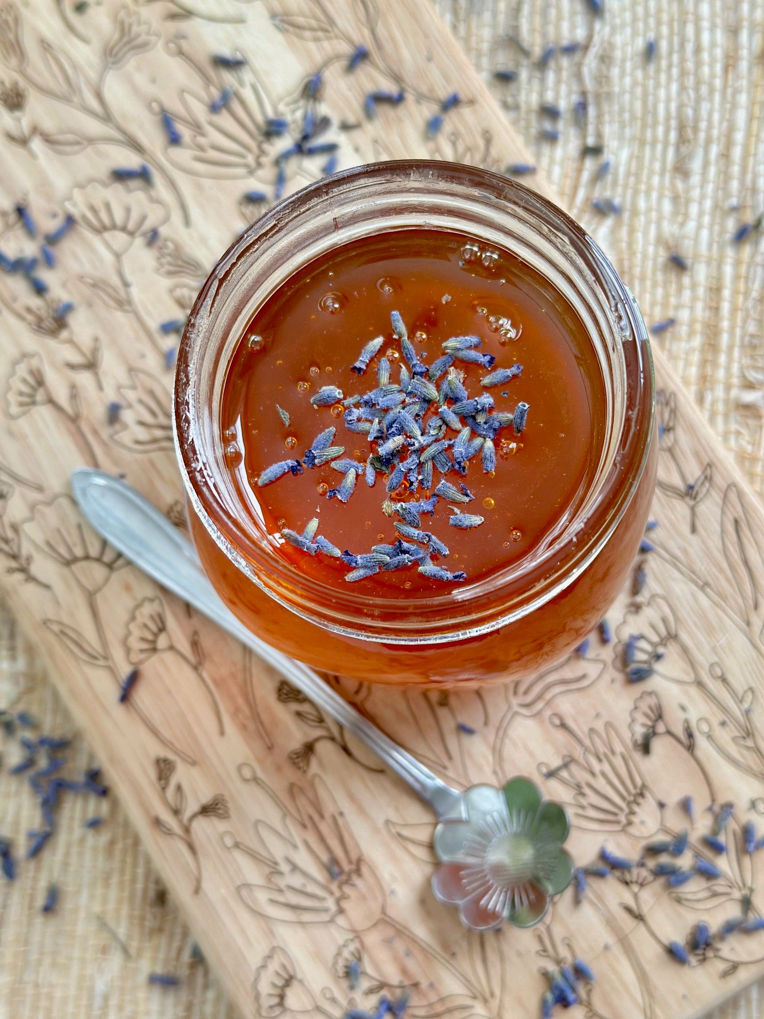Lavender in a jar with honey and a spoon.