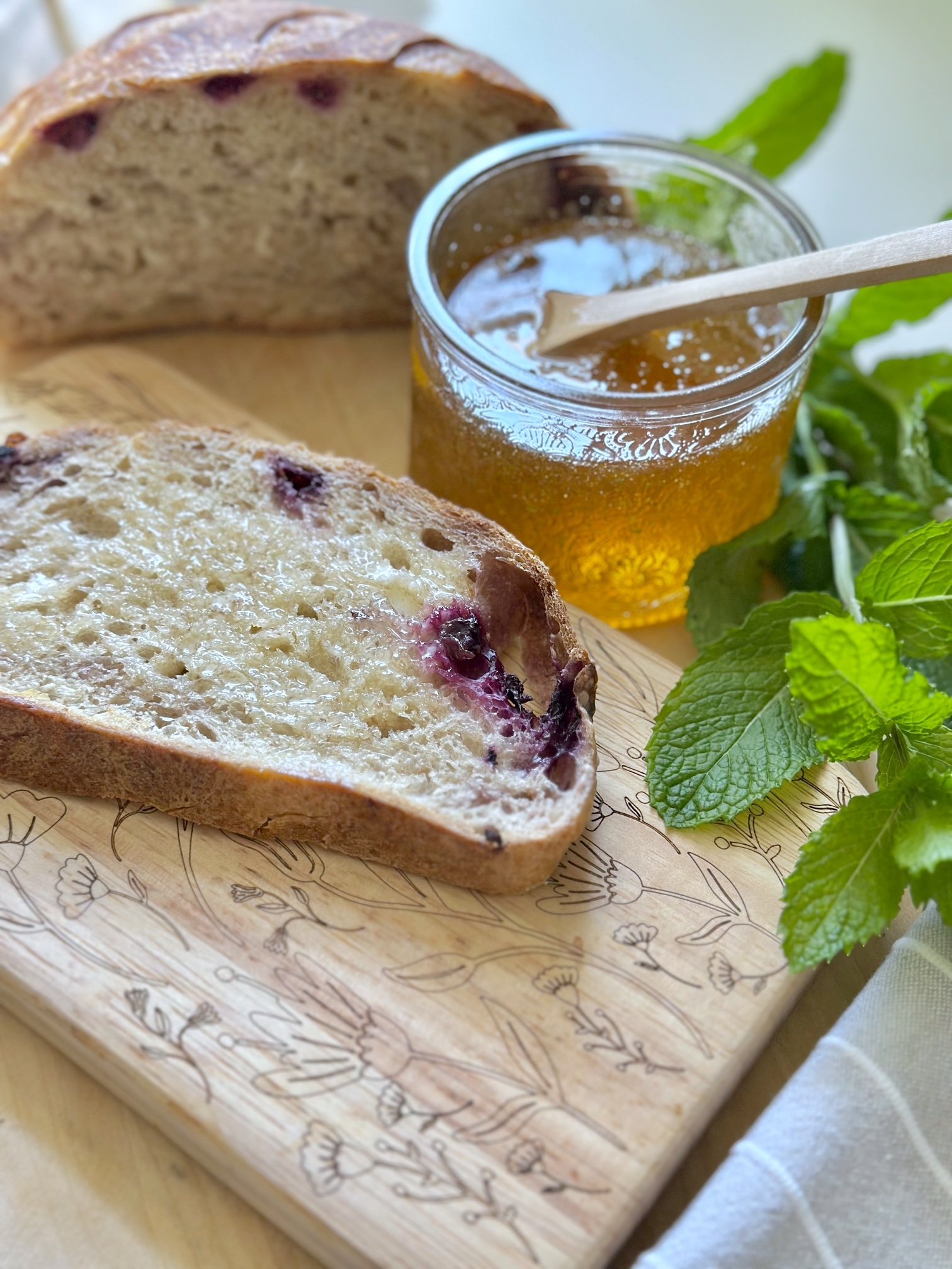 A piece of blueberry sourdough toast with mint honey.