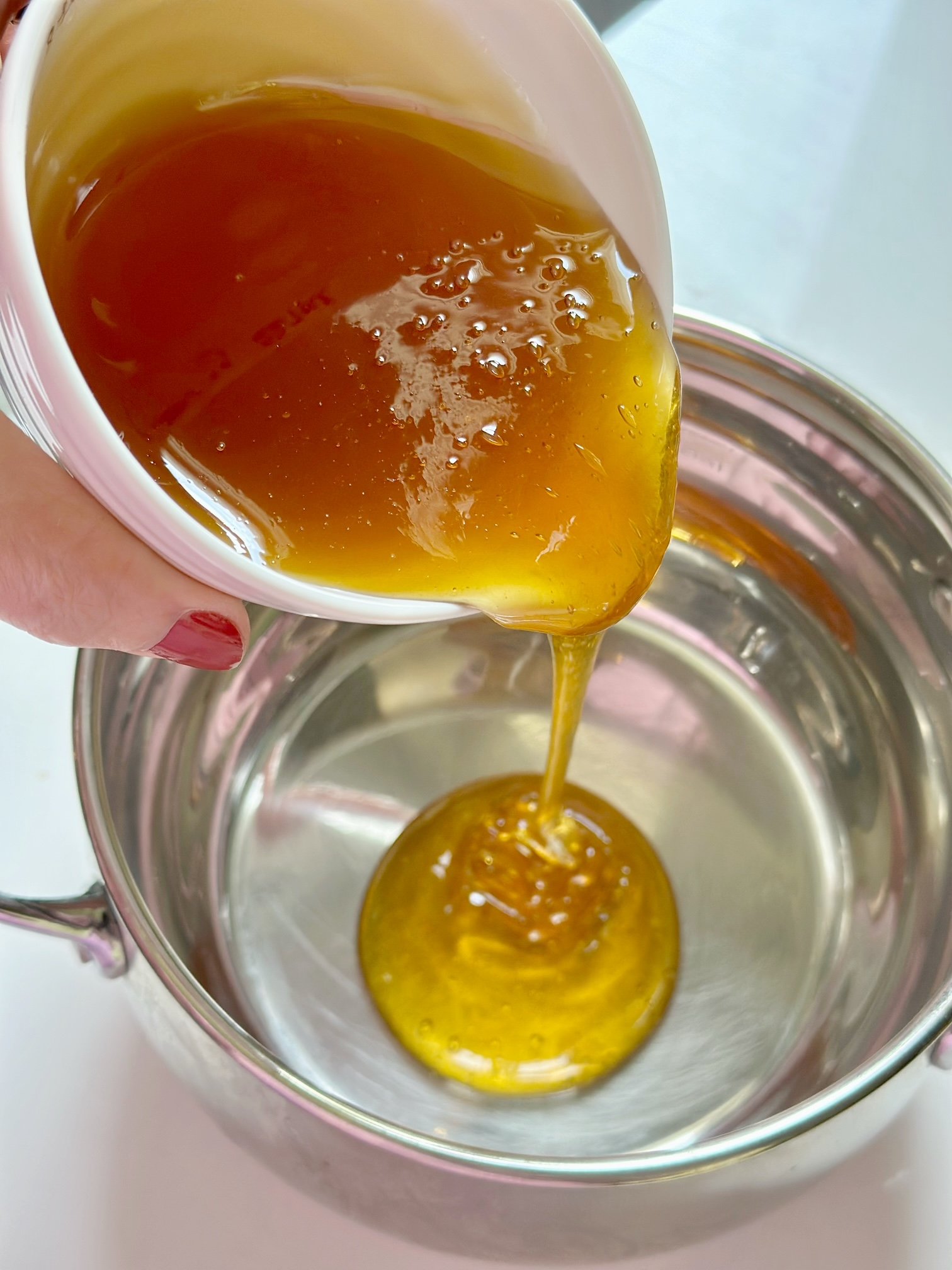 Pouring 1 cup of honey in a pan to heat.