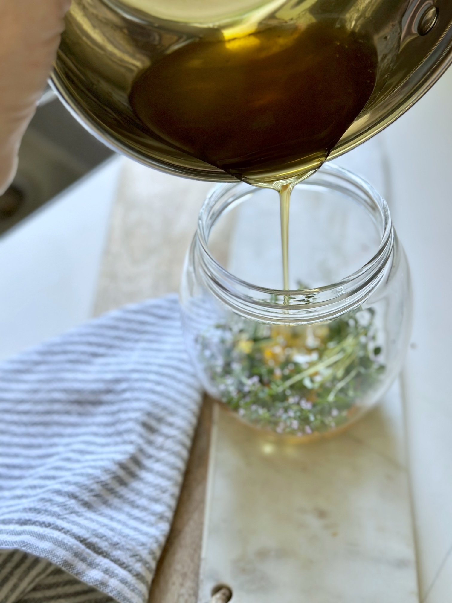 Pouring the warm honey over the fresh thyme.