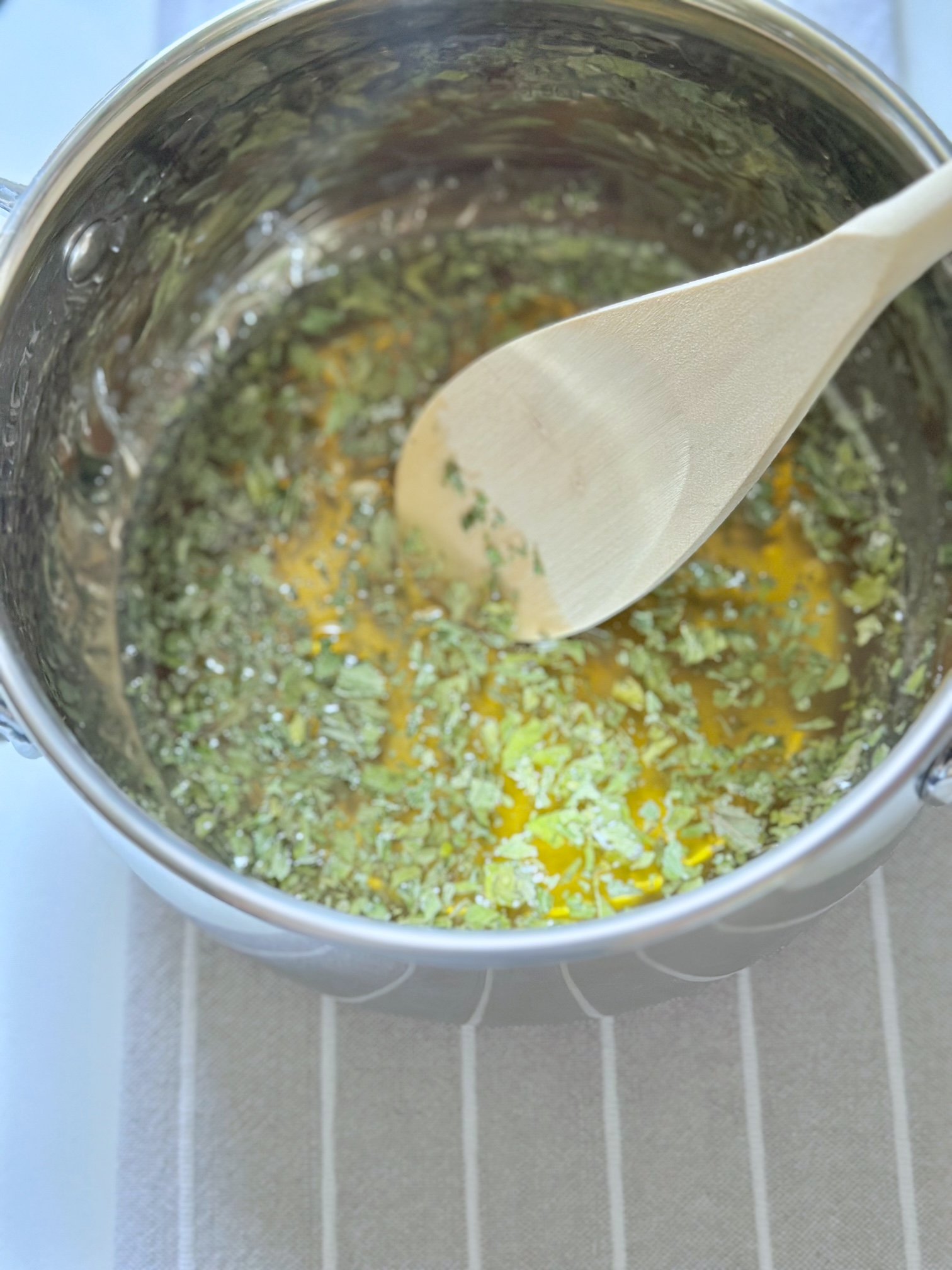 Mixing the spearmint into the warm honey to let steep.