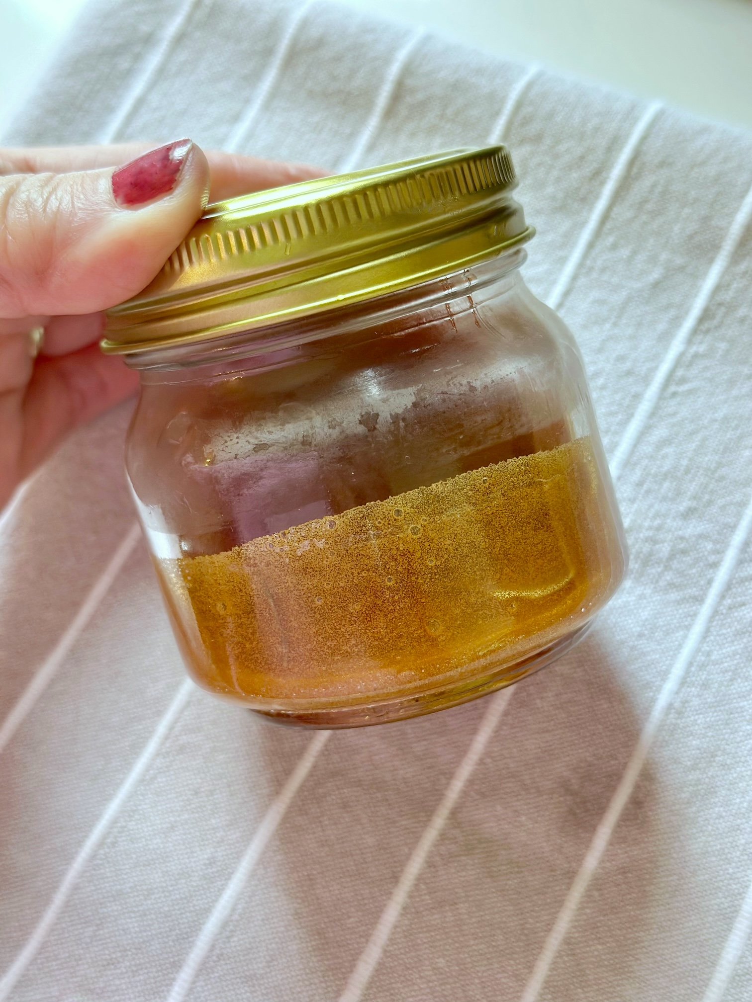 Storing rosemary honey in a jar.