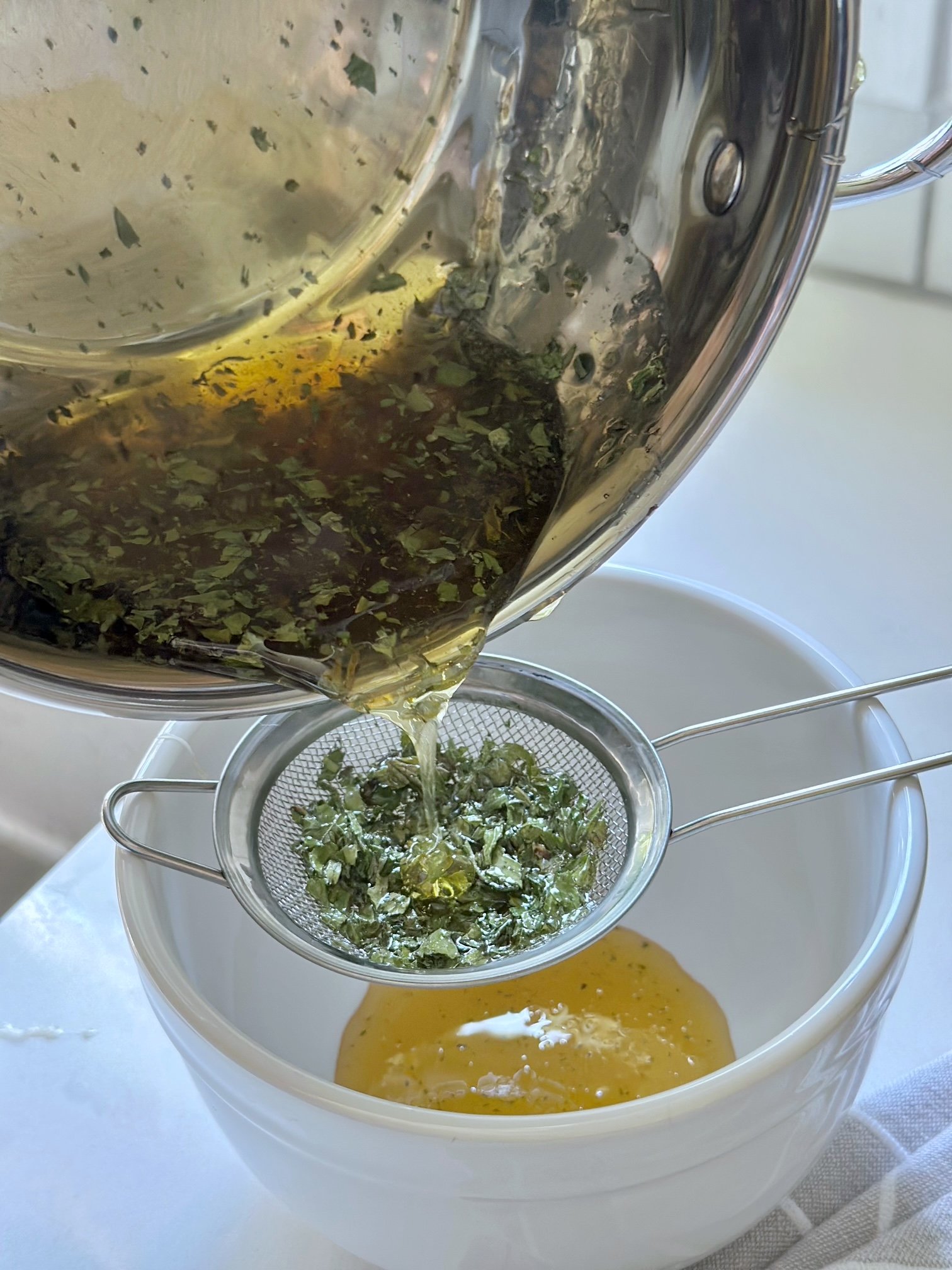 Straining the mint from the honey.